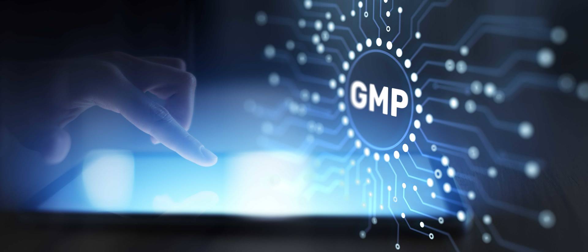 Hand pekar på en digital skärm med texten “GMP” omgiven av kretsmönster.