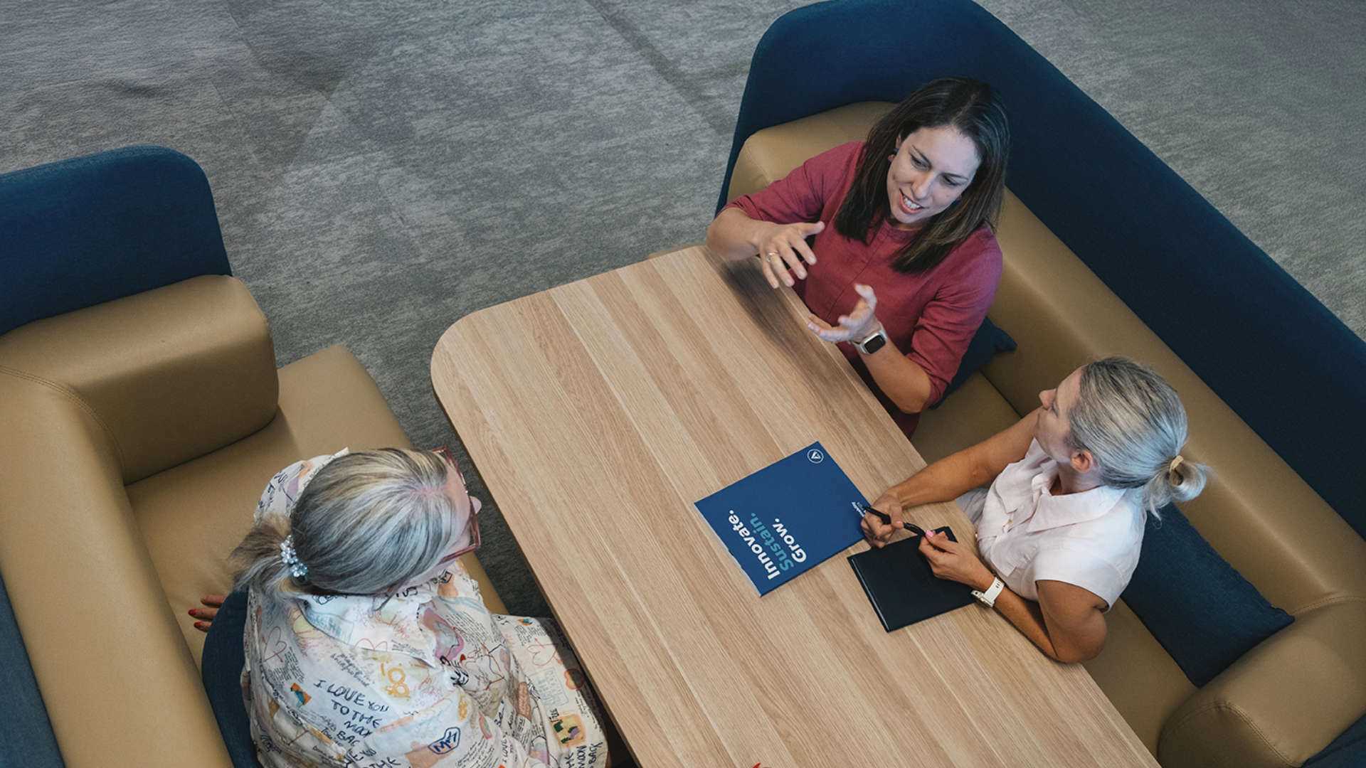 Three people discussing at a table