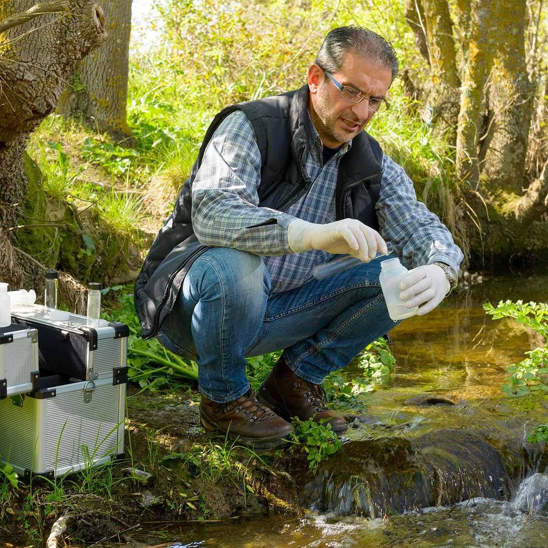 View of a Biologist take a sample in a river.