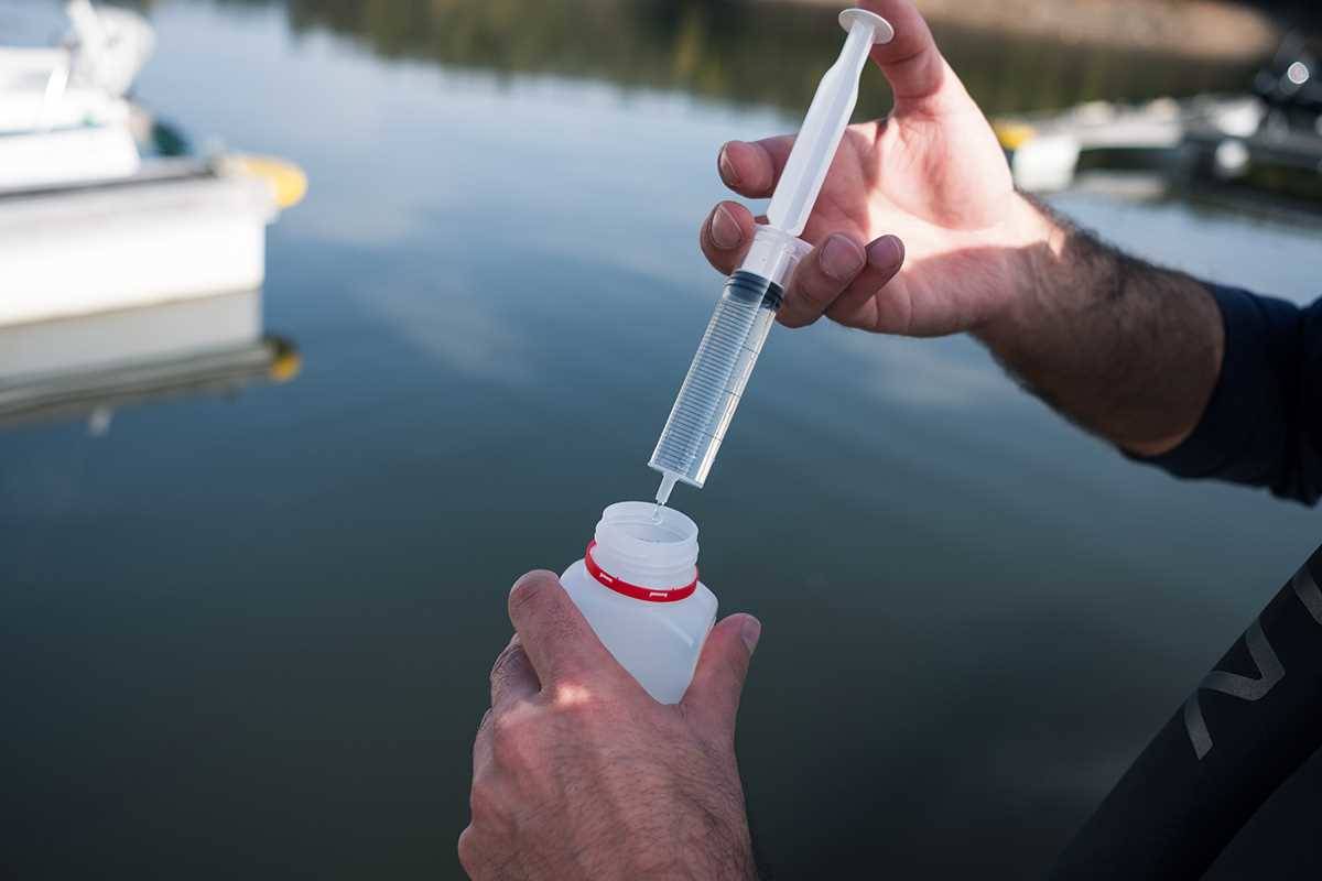 Equipamento de amostragem a recolher água na superfície de uma barragem.