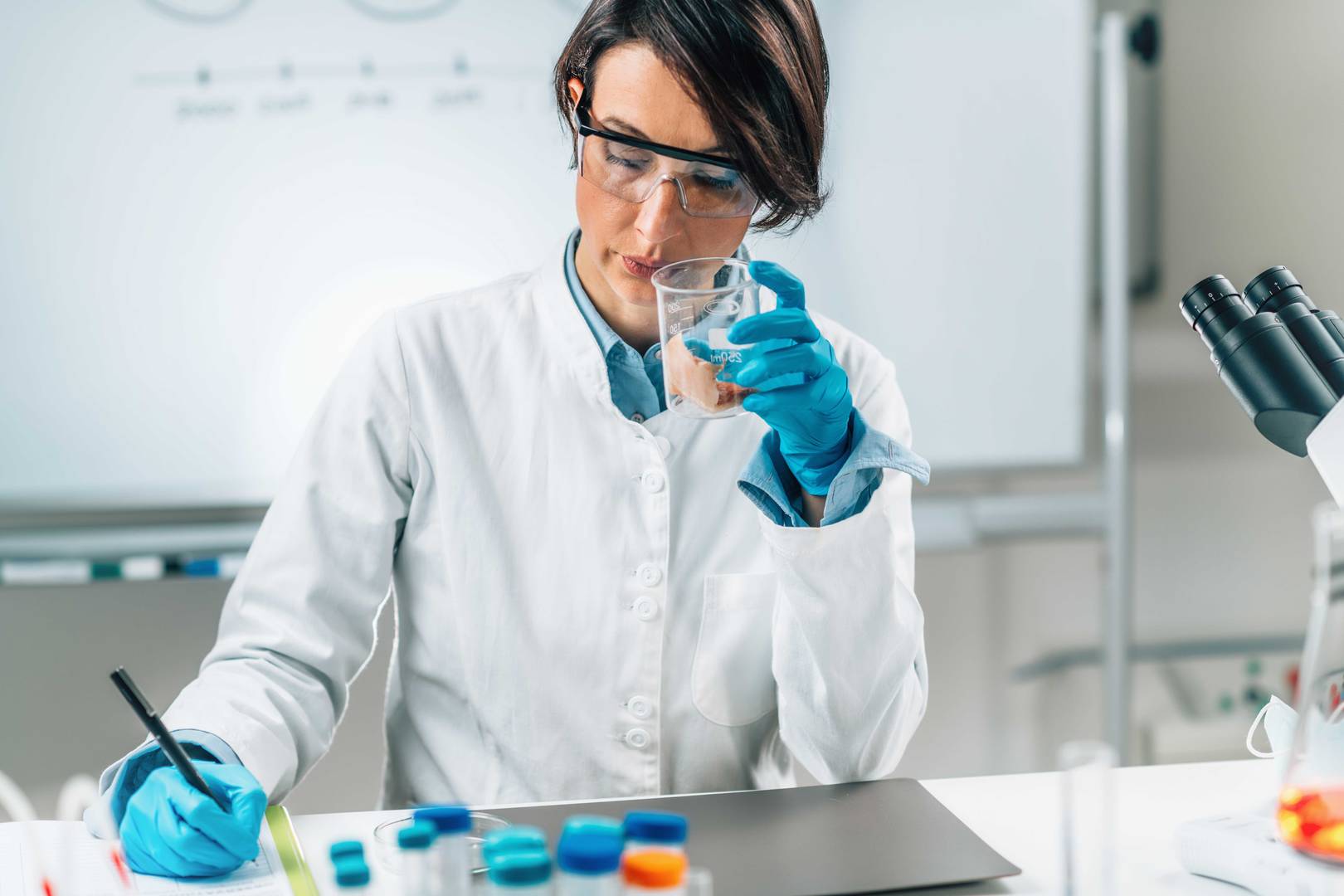 Senzorická analýza vzorku mořské ryby ve zkumavce. Inspektor bezpečnosti potravin čichá vzorek v laboratoři.