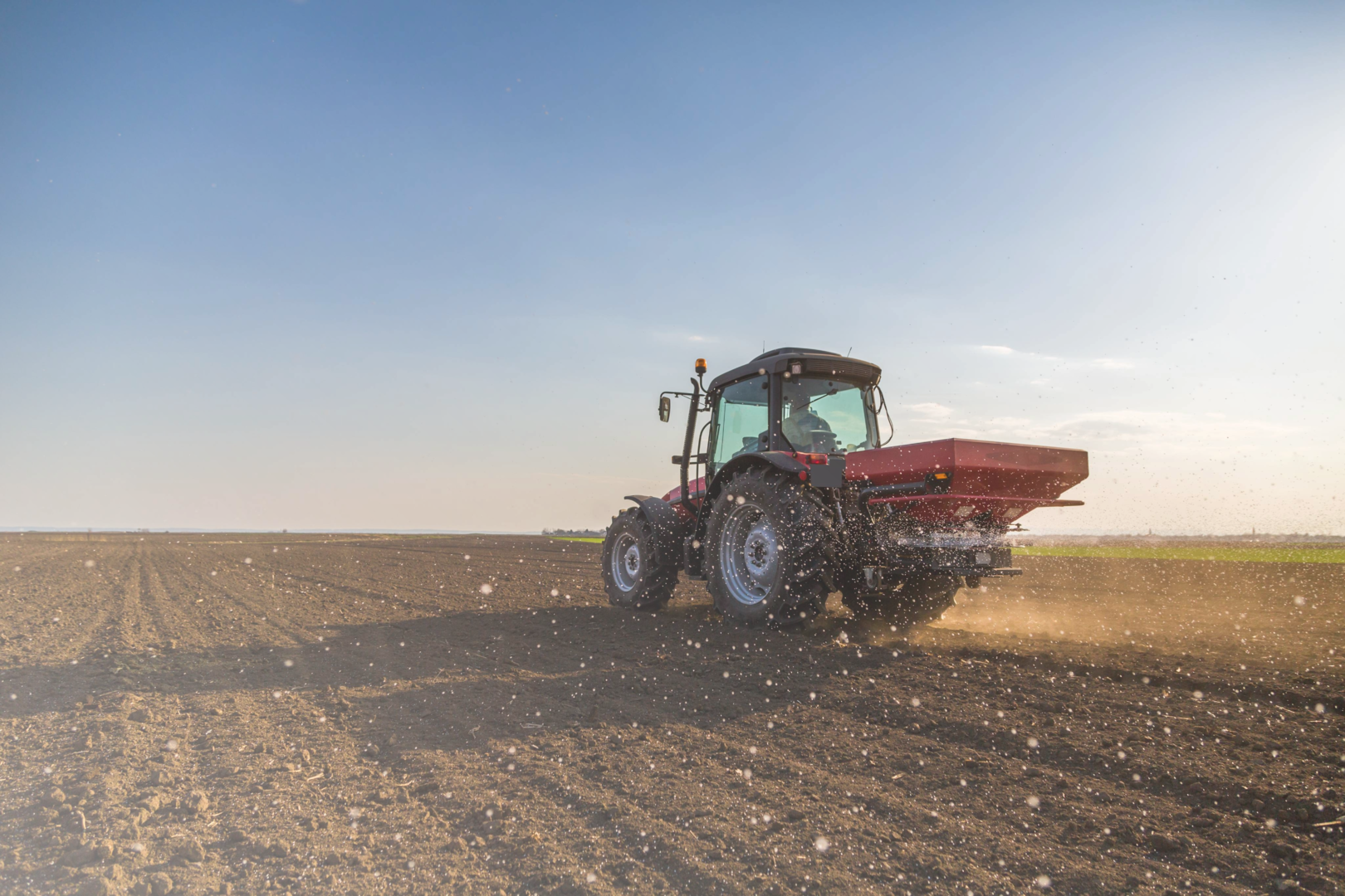 Trecker bringt Dünger auf dem Feld aus
