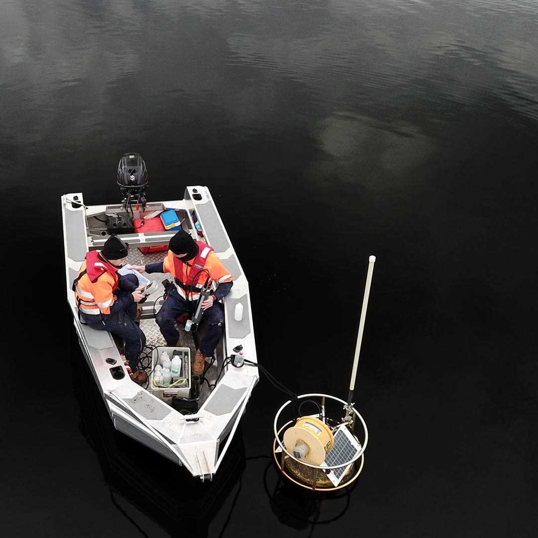 Hydrographers in inflatable rib on a lake checking measuring equipment