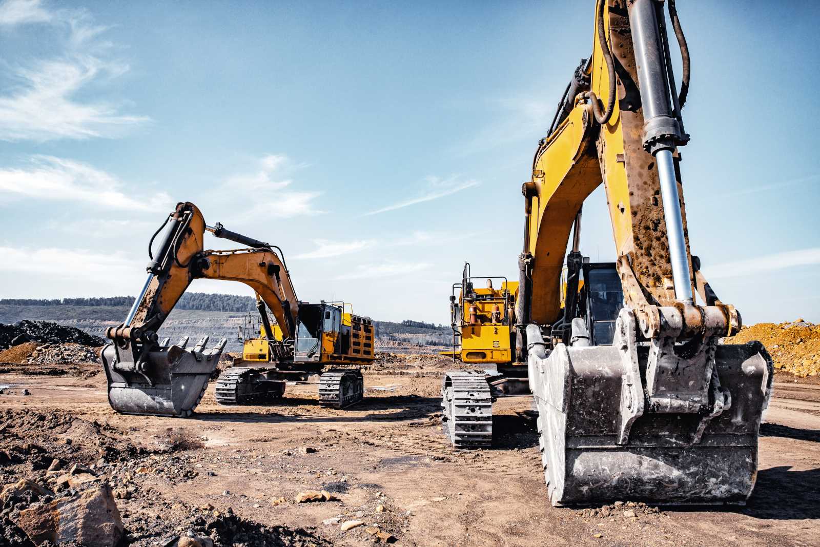 Group of yellow excavator working on construction open mining site.